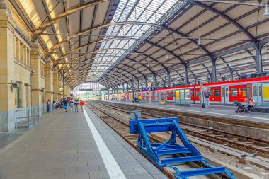 Wiesbaden, Germany - July 22, 2022: people waiting for the train at historic classicistic train station in Wiesbaden, Germany.