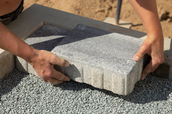 工匠把铺路石铺成层 在房子的四合院的沙质地基上铺灰色混凝土铺板 — 图库照片