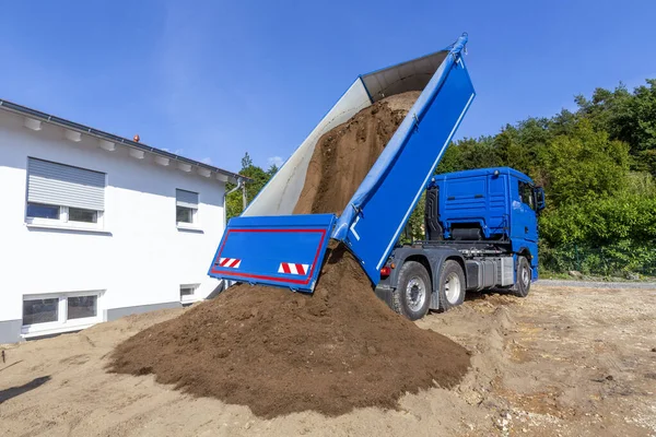 ドイツの建設現場でトラックのベッドから土を注入してトラックを積み降ろし — ストック写真