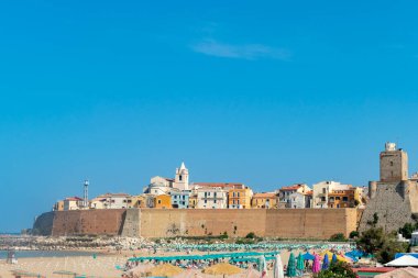 Eski Termoli kasabasının panoramik manzarası plaj şemsiyeleri, renkli evler ve Svevo Kalesi, Termoli, İtalya