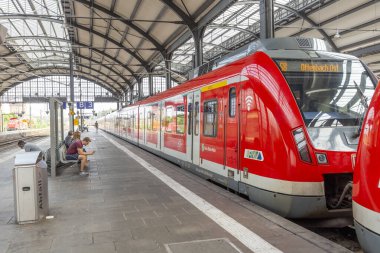 Wiesbaden, Almanya - 27 Ağustos 2022: İnsanlar, Frankfurt Tren İstasyonu 'nun küçük bir kopyası olan Wiesbaden' deki klasik tren istasyonunda kalkış için tren istasyonunda bekliyorlar..