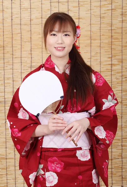 Joven asiática mujer en kimono holding papel ventilador — Foto de Stock