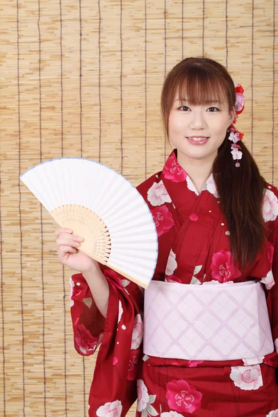 Joven asiática mujer en kimono holding papel ventilador —  Fotos de Stock