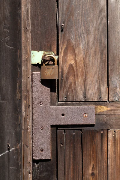 Old padlock on a wooden door — Stock Photo, Image