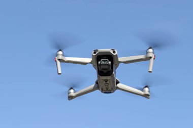 Havada uçan İHA ve açık mavi gökyüzü arkaplanı  