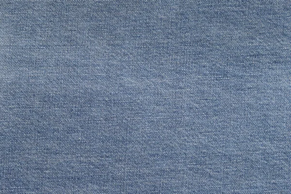 色あせたブルーの生地のデニムの背景 ブルーの変色したジーンズのクローズアップ — ストック写真