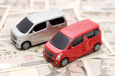 Small toy car on Japanese ten thousand yen bills banknotes 