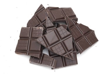 Beyaz arka planda izole edilmiş siyah çikolata parçaları.  