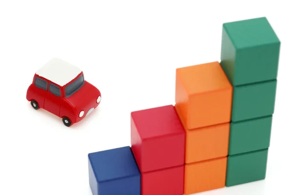 白い背景に小さなおもちゃの車と木製のカラフルな建物のブロック — ストック写真