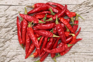 Kirli ahşap arka planda kırmızı biber bitkileri yığını   