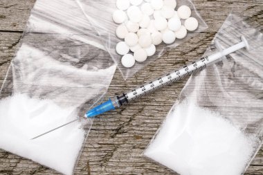 Uyuşturucu enjeksiyonu şırıngası ve ahşap bir çantada pişmiş eroin. 