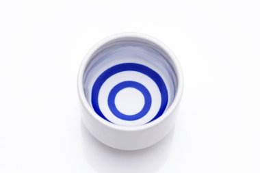 Beyaz arka planda geleneksel seramik bir ochoko fincanda Japon sake 'si. 
