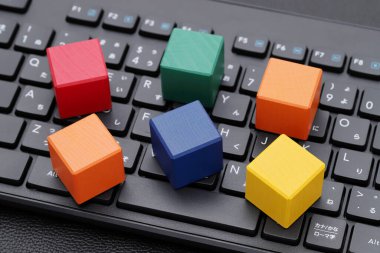 Siyah masadaki bilgisayar klavyesinde tahta oyuncak blokları 