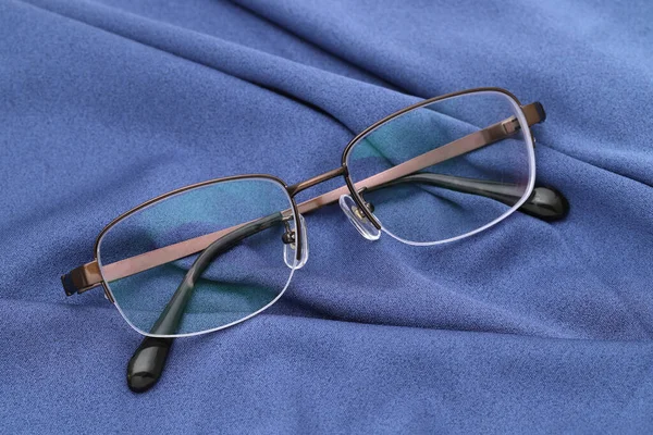 スタイリッシュな視力メガネと青いガラスのクリーニング布の背景 — ストック写真