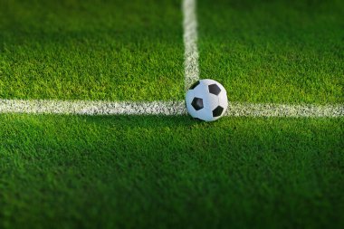 Çayırdaki çimlerin üzerinde güneş ışığında klasik futbol topu 