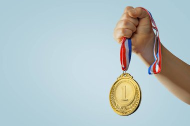 Kadın el kaldırıyor, altın madalyayı gökyüzüne karşı tutuyor. ödül ve zafer konsepti