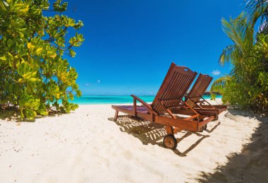 Family relaxing on the beach overlooking the sea in Maldives