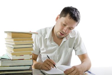Adam kütüphanede kitap okuyor.