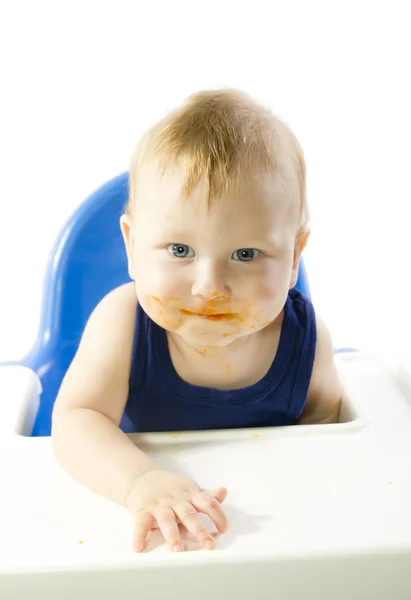 Smiling gray-eyed child feeding pumpkin puree — Stock Photo, Image