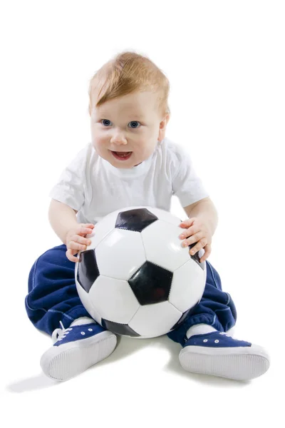 Barnet sitter på golvet med fotboll boll — Stockfoto