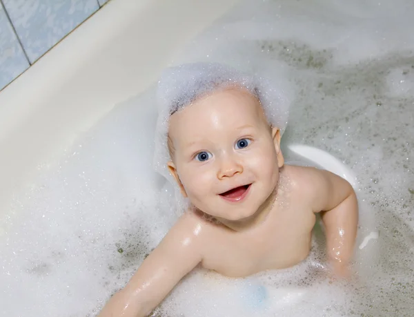 Blå-eyed baby simning i badet — Stockfoto