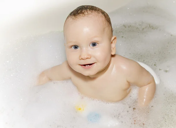 Ребенок с седыми глазами плавает в ванне — стоковое фото