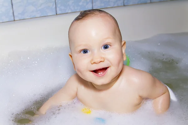 Bébé aux yeux bleus nageant dans le bain — Photo