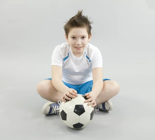 Junge im weißen T-Shirt mit Fußballball — Stockfoto