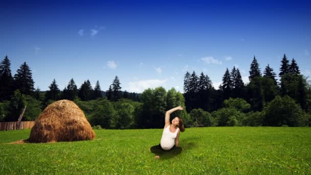 Mulher grávida exercitando no prado verde — Vídeo de Stock