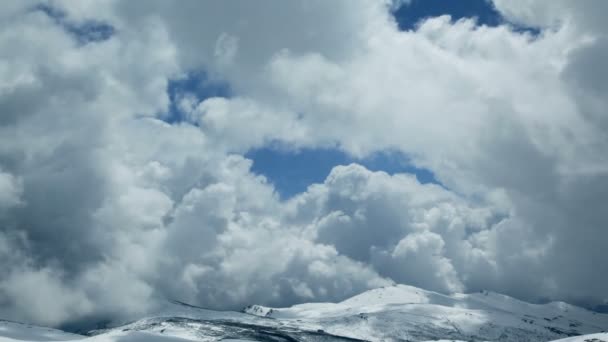 Stormig tid förfaller moln på toppen snöiga berget — Stockvideo