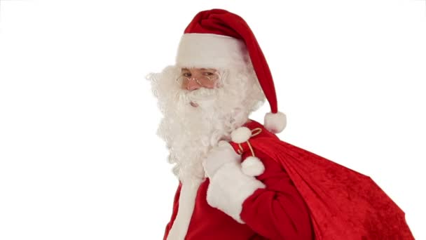 Santa Claus carrying his bag, looks at the camera sends a blow kiss and wave, white — Stock Video