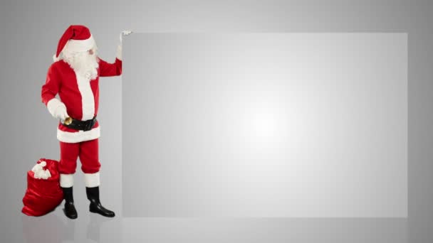 Άγιος Βασίλης τίναγμα κουδούνι, παρουσιάζοντας ένα λευκό φύλλο — Αρχείο Βίντεο