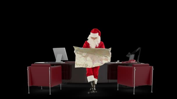 Santa claus leyendo un mapa en su oficina de Navidad moderno, contra negro — Vídeo de stock