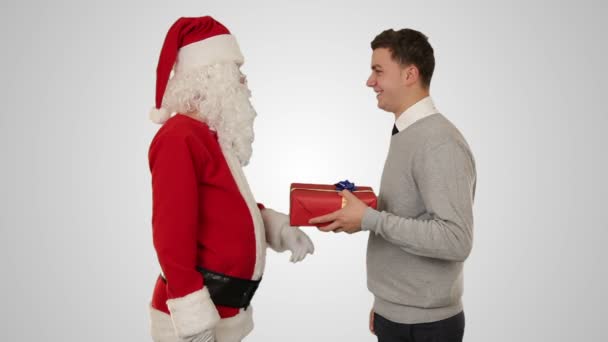 Jovem empresário receber um presente de Papai Noel, apertando as mãos, contra branco — Vídeo de Stock