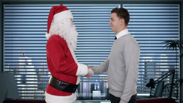 Santa claus a mladý podnikatel v moderní kancelářské, třesoucí se ruce a při pohledu na fotoaparát — Stock video