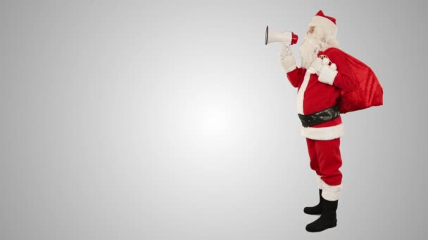 Moș Crăciun cu un difuzor care face un anunț, vedere laterală, împotriva albului — Videoclip de stoc