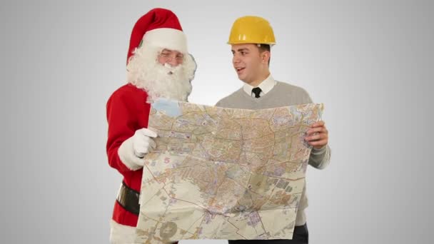 Санта-Клаус с молодым архитектором, чтение карты, против белых — стоковое видео