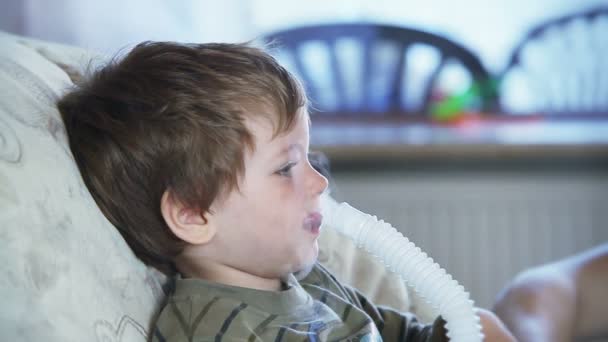 Niño enfermo con nebulizador para inhalar el medicamento — Vídeo de stock