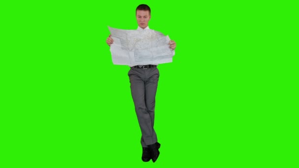 Young businessman reading a map and sitting, Green Screen — Stock Video