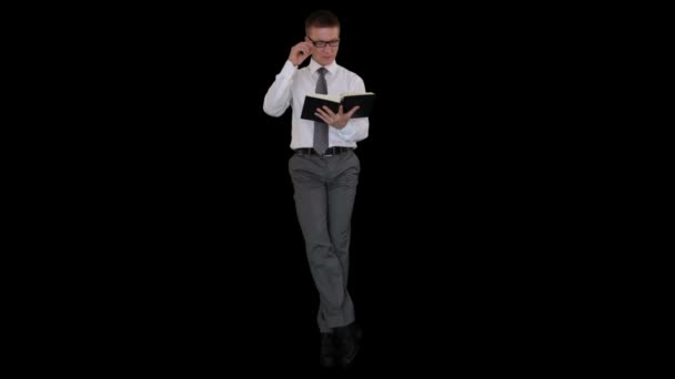 Businessman reading book against black — Stock Video