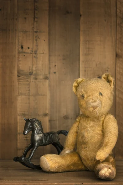 Urso de pelúcia vintage e cavalo de balanço — Fotografia de Stock