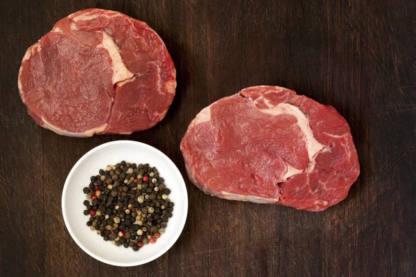 Filetes de carne cruda y granos de pimienta —  Fotos de Stock