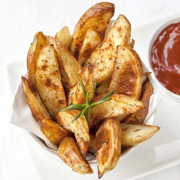 Aardappel partjes met rozemarijn en ketchup — Stockfoto