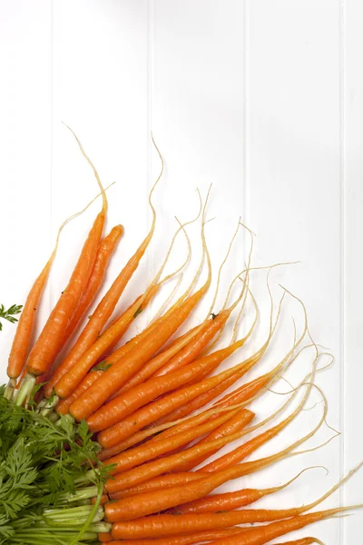 Bunch of Baby Carrots over White Timber — Stok Foto