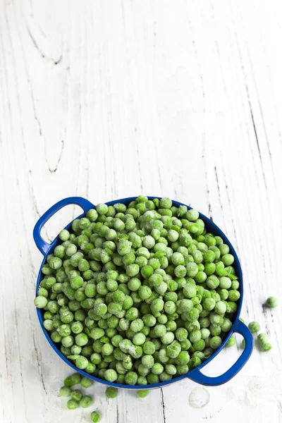 Guisantes congelados en colador azul — Foto de Stock