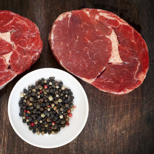 Filetes de carne cruda con granos de pimienta — Foto de Stock