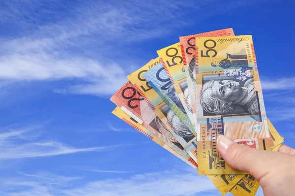 Un puñado de dinero australiano sobre Blue Sky . — Foto de Stock