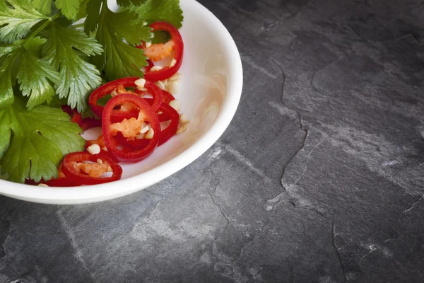 Chili y cilantro en tazón sobre pizarra —  Fotos de Stock