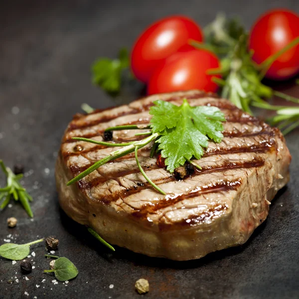 Gegrilde steak met kruiden en tomaten — Stockfoto