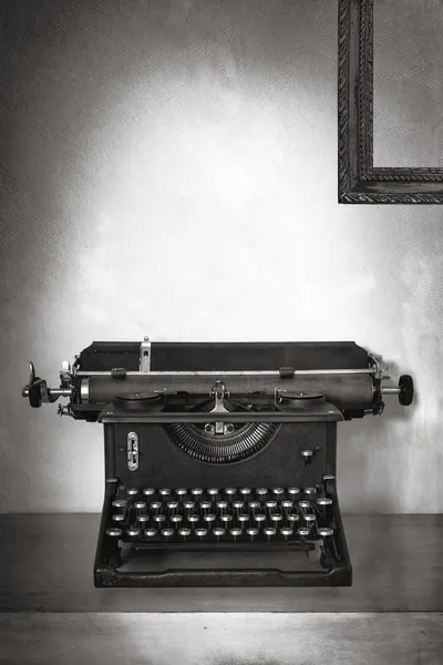 Винтажная пишущая машинка на старом столе с гранж-фоном — стоковое фото
